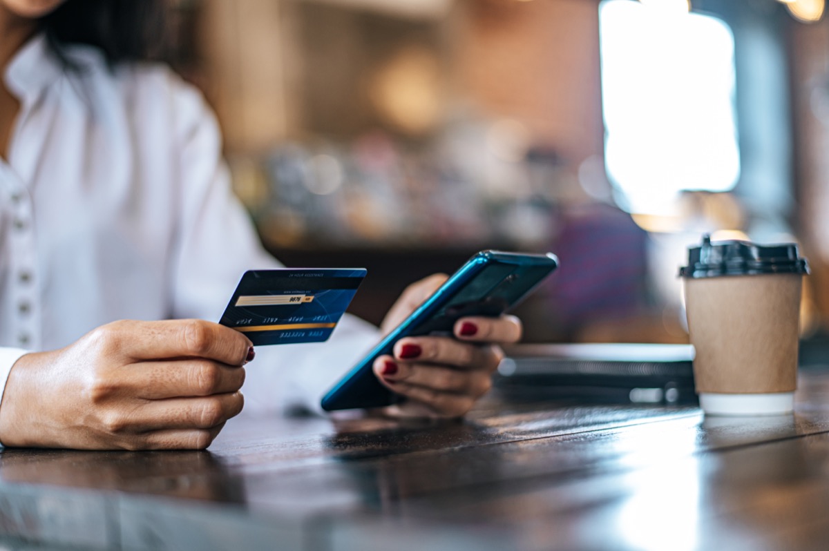 person on phone entering credit card info